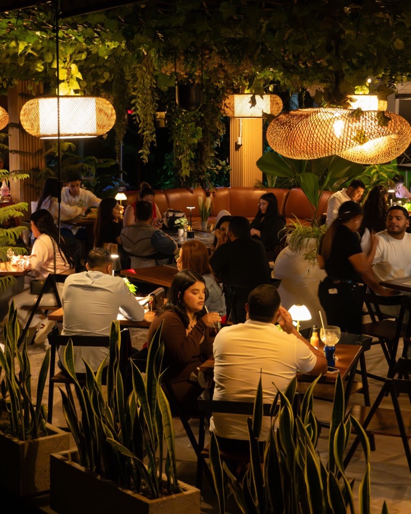 Salón lleno de noche bajo lámparas de mimbre